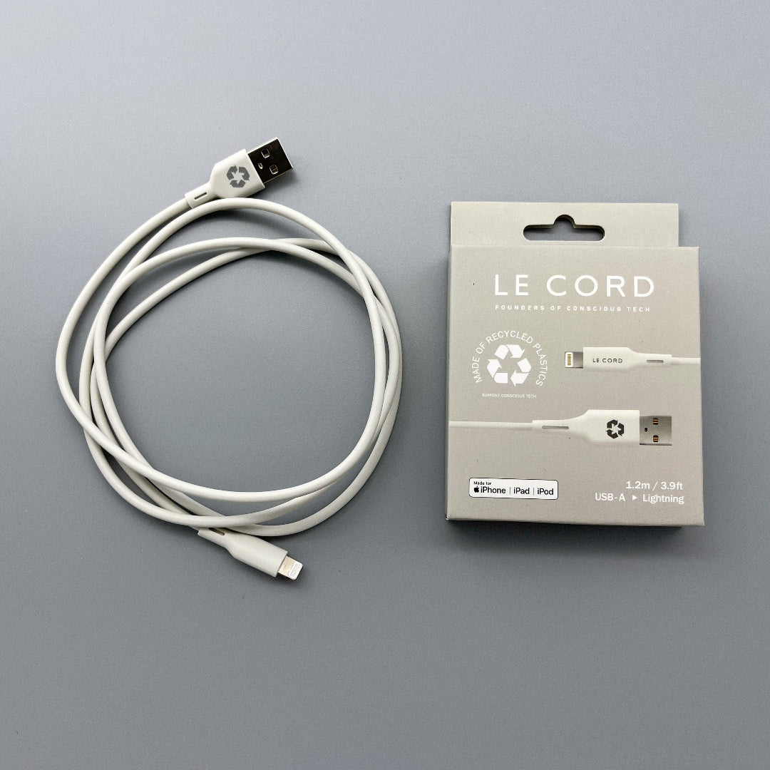 A light grey iPhone cable made from recycled plastic, displayed next to its packaging that reads 'LE CORD' and 'ECO-FRIENDLY RECYCLED PLASTIC'.